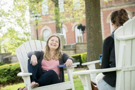 学生在阿迪朗达克椅子在校园外的老主要在杂酚油影响照片拍摄5月1日, 2019 at Washington & Jefferson College.